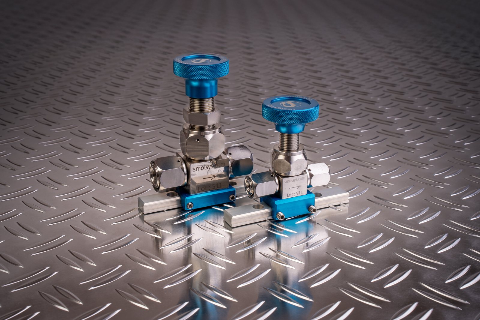 smolsys tritium valves with blue handwheels on a stainless steel surface
